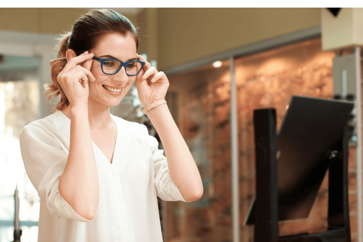 a woman trying on glasses in a optical